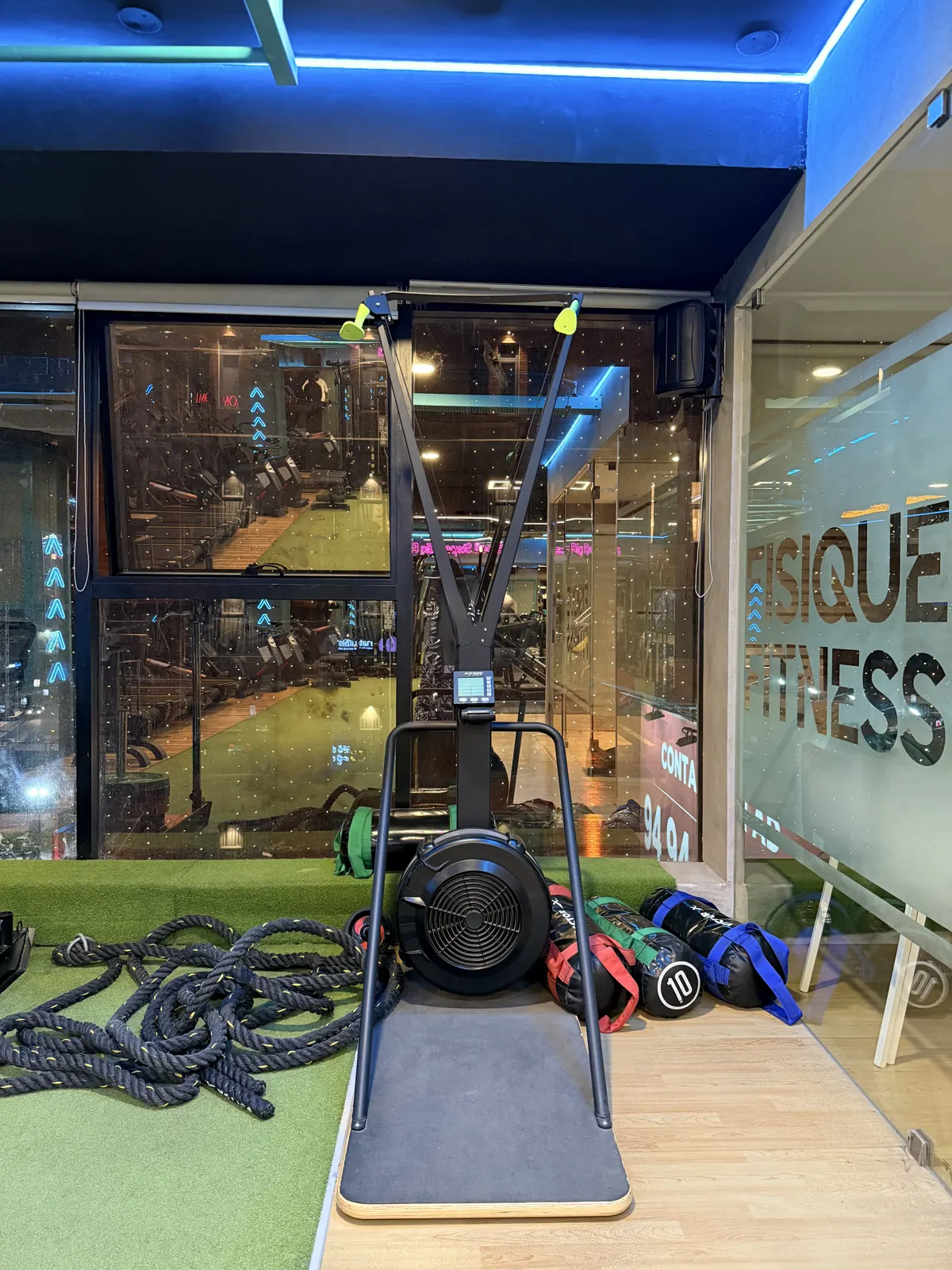 Battle ropes and a sled on the turf by the window